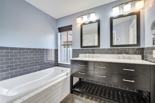 full bath featuring a bath, double vanity, and a sink
