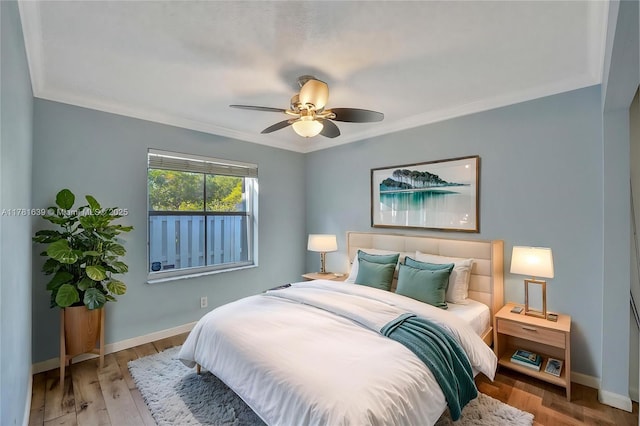 bedroom with wood finished floors, ceiling fan, baseboards, and ornamental molding