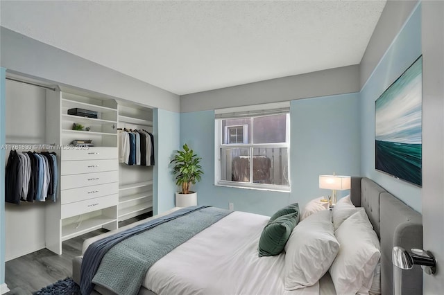 bedroom featuring a closet, wood finished floors, and a textured ceiling