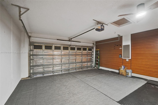 garage with a garage door opener and electric panel
