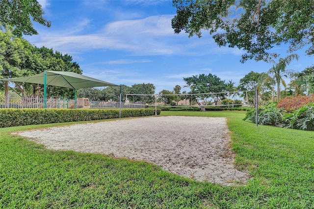 view of community with playground community, fence, volleyball court, and a lawn