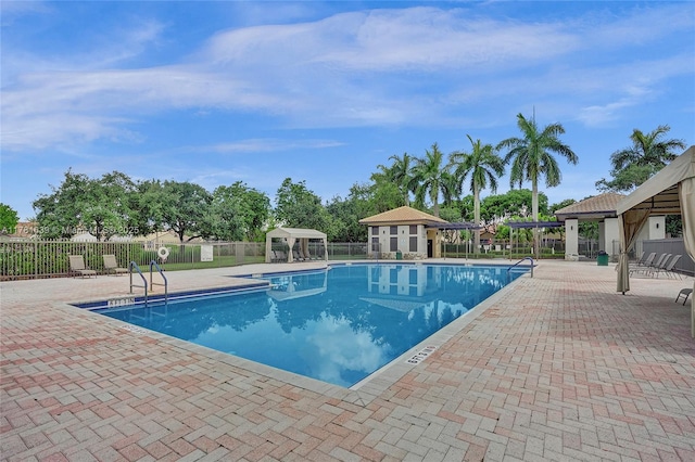 community pool featuring a patio area, a gazebo, and fence