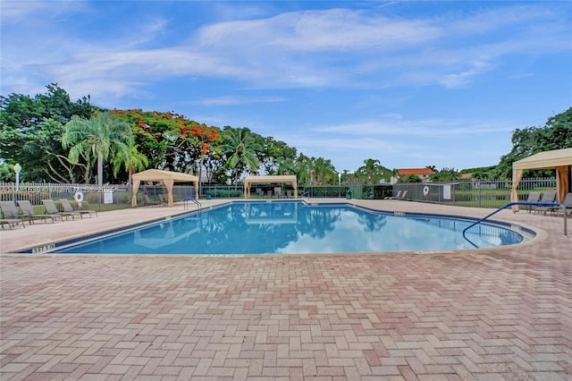 community pool featuring a gazebo, fence, and a patio