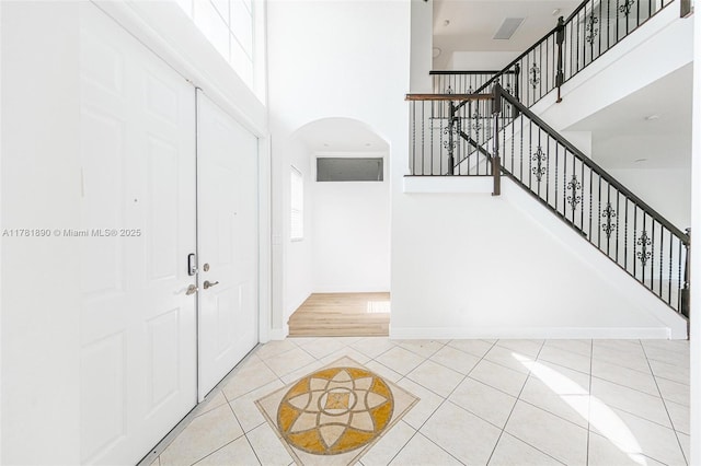 4981 SW 173rd Ave, Miramar, FL 33029 - entrance foyer with arched walkways, a towering ceiling, tile patterned floors, stairs, and baseboards
