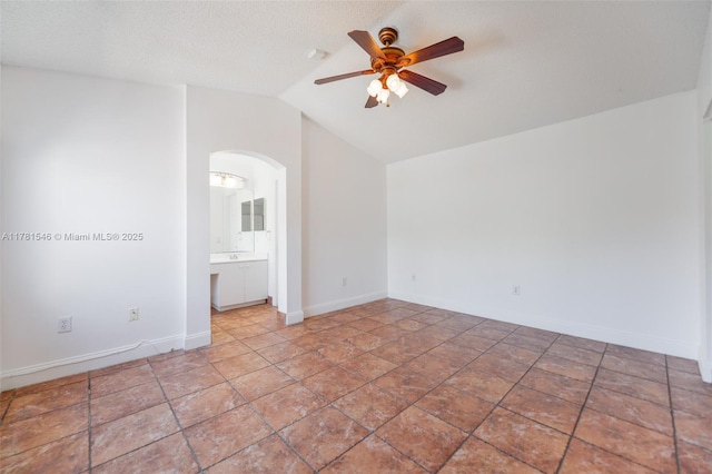 1551 Seagrape Way, Hollywood, FL 33019 - spare room featuring arched walkways, ceiling fan, baseboards, and vaulted ceiling