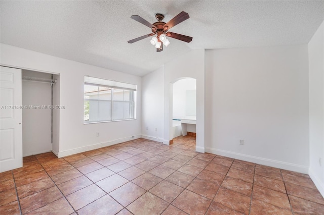 1551 Seagrape Way, Hollywood, FL 33019 - unfurnished bedroom featuring ceiling fan, arched walkways, a textured ceiling, lofted ceiling, and a closet