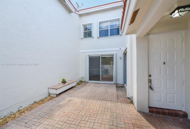 1551 Seagrape Way, Hollywood, FL 33019 - view of exterior entry with a patio and stucco siding