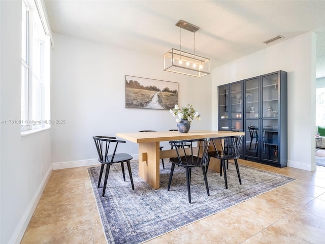 dining area with baseboards, a healthy amount of sunlight, visible vents, and light tile patterned floors