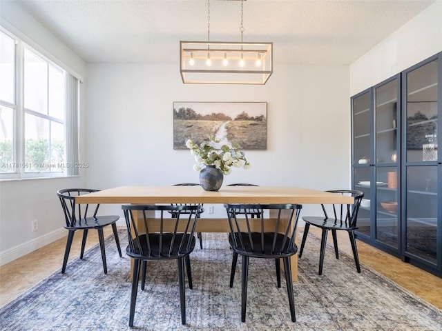 dining area with baseboards and a textured ceiling