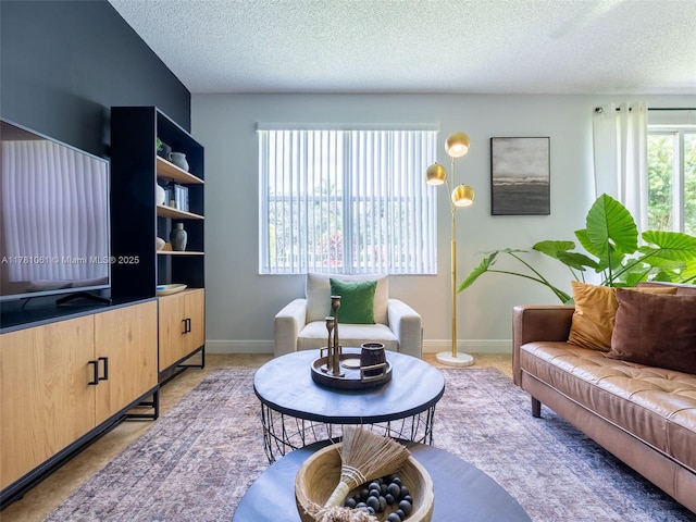living area featuring a textured ceiling and baseboards