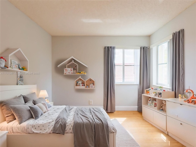 bedroom featuring baseboards and light wood-style flooring