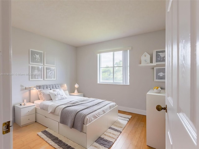 bedroom with baseboards and light wood-style floors
