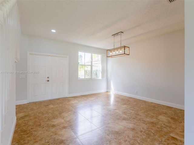 spare room with baseboards, a textured ceiling, and recessed lighting