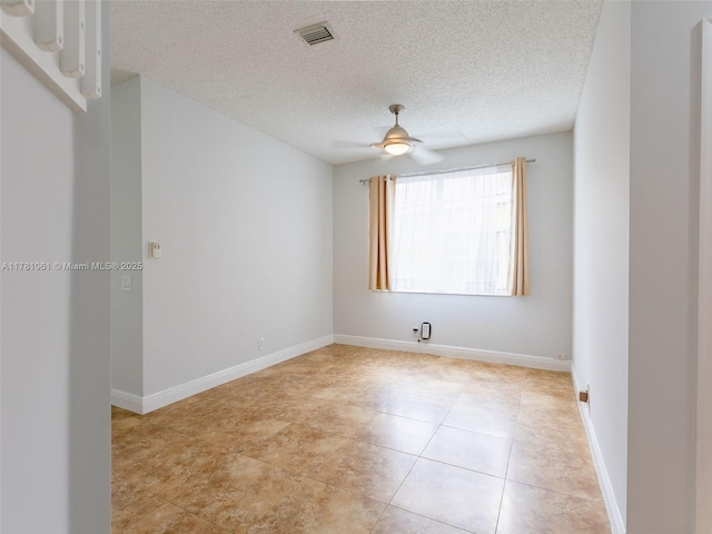 spare room with a textured ceiling, baseboards, visible vents, a ceiling fan, and light tile patterned floors