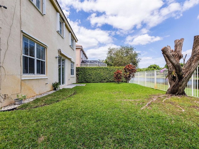 view of yard featuring fence and a water view