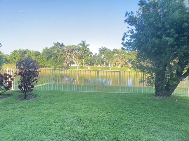 view of yard featuring a fenced backyard and a water view