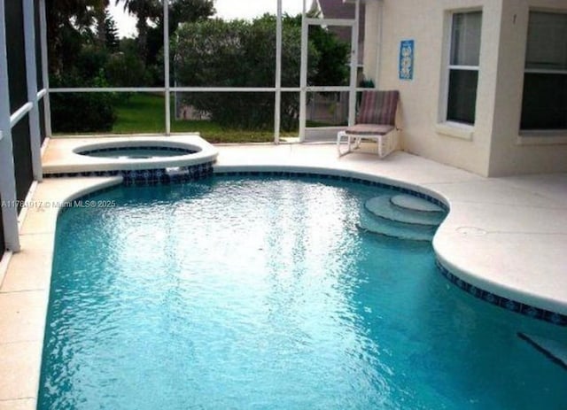 view of pool featuring a lanai, a patio, and a pool with connected hot tub
