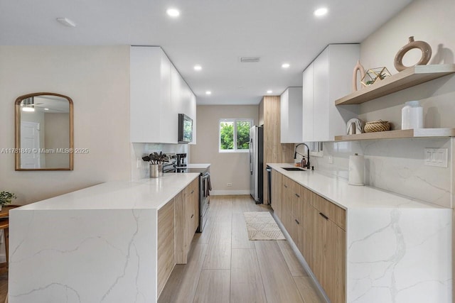 509 NE 29th St, Wilton Manors, FL 33334 - kitchen featuring appliances with stainless steel finishes, modern cabinets, open shelves, recessed lighting, and light wood-type flooring