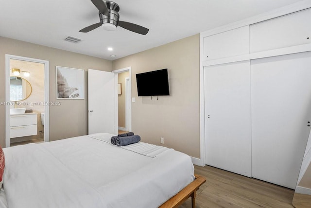 509 NE 29th St, Wilton Manors, FL 33334 - bedroom with light wood-type flooring, a closet, ensuite bath, and a ceiling fan
