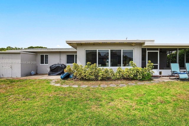 509 NE 29th St, Wilton Manors, FL 33334 - back of house featuring a sunroom, stucco siding, and a yard