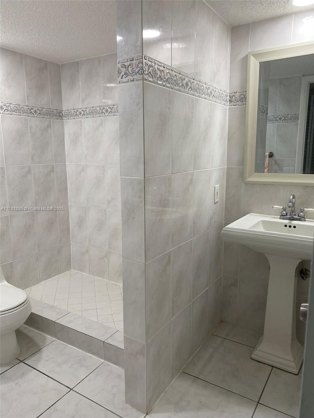 full bath with tile patterned floors, a textured ceiling, tile walls, and toilet