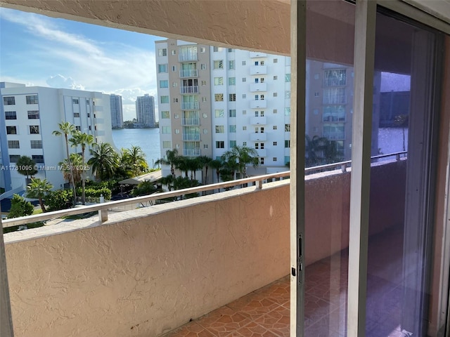 balcony featuring a water view and a city view