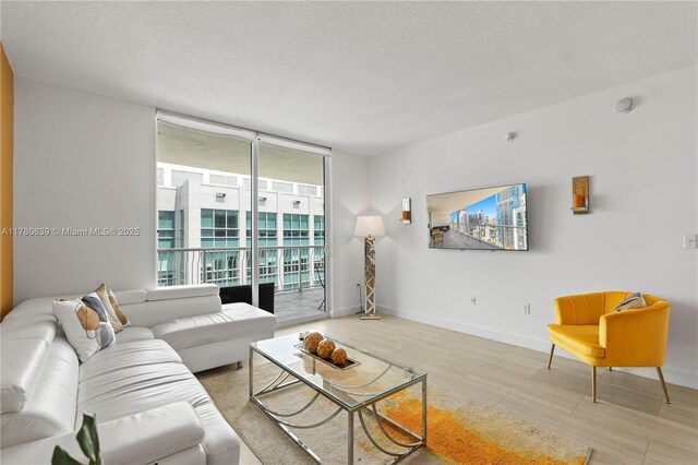 1200 Brickell Bay Dr Ph 4218, Miami, FL 33131 - living room with a wall of windows, a textured ceiling, wood finished floors, and baseboards