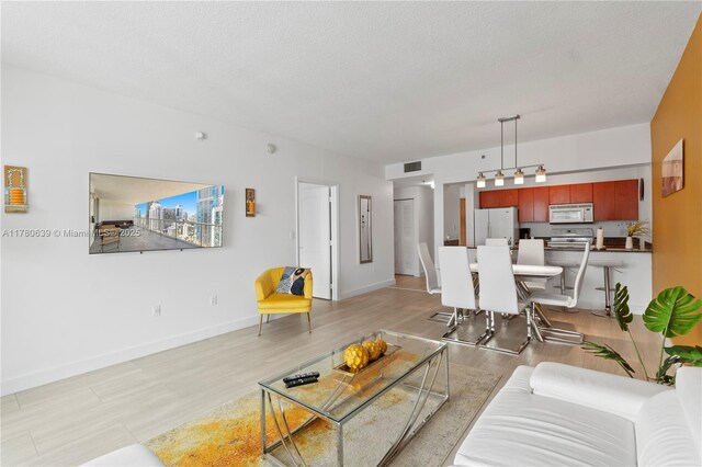1200 Brickell Bay Dr Ph 4218, Miami, FL 33131 - living area featuring light wood finished floors, baseboards, and a textured ceiling