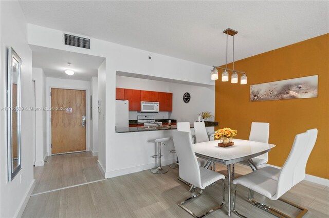 1200 Brickell Bay Dr Ph 4218, Miami, FL 33131 - dining area with light wood-style flooring and baseboards