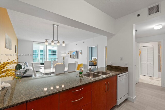 1200 Brickell Bay Dr Ph 4218, Miami, FL 33131 - kitchen with dishwasher, a sink, a peninsula, dark stone countertops, and decorative light fixtures
