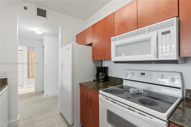 1200 Brickell Bay Dr Ph 4218, Miami, FL 33131 - kitchen featuring white appliances, brown cabinetry, and dark stone countertops