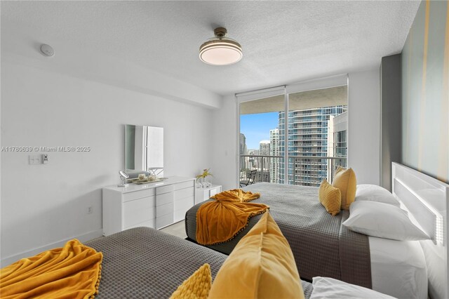 1200 Brickell Bay Dr Ph 4218, Miami, FL 33131 - bedroom with access to outside, floor to ceiling windows, a view of city, and a textured ceiling