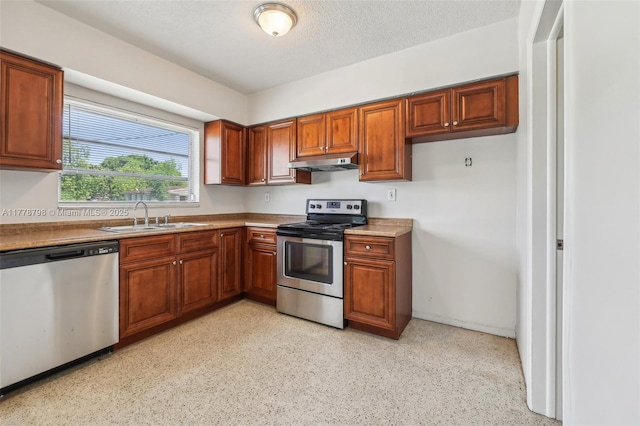 2650 SW 76th Ave, Miami, FL 33155 - kitchen featuring stainless steel appliances, under cabinet range hood, brown cabinetry, and a textured ceiling