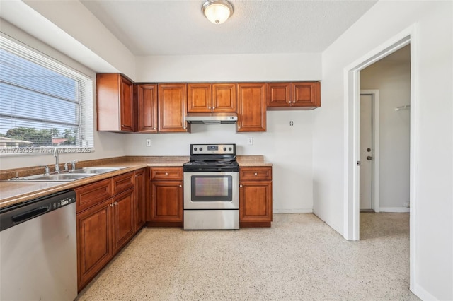 2650 SW 76th Ave, Miami, FL 33155 - kitchen featuring appliances with stainless steel finishes, under cabinet range hood, brown cabinets, and light countertops