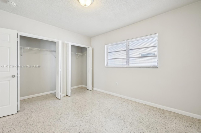 2650 SW 76th Ave, Miami, FL 33155 - unfurnished bedroom featuring two closets, speckled floor, and a textured ceiling