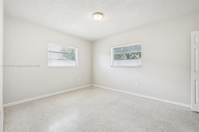 2650 SW 76th Ave, Miami, FL 33155 - empty room with speckled floor, healthy amount of natural light, and a textured ceiling