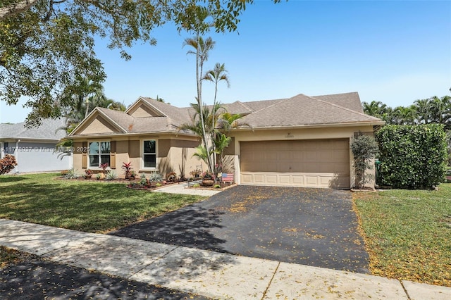 ranch-style house featuring driveway, stucco siding, a garage, and a front yard