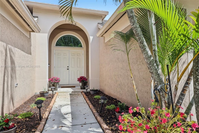 view of exterior entry featuring stucco siding