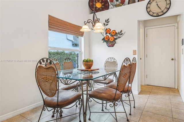 dining space with a chandelier, light tile patterned floors, and baseboards