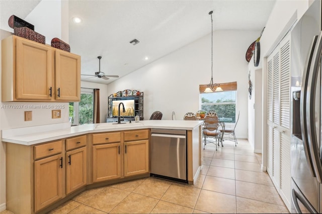 kitchen featuring a sink, a peninsula, vaulted ceiling, ceiling fan with notable chandelier, and stainless steel appliances