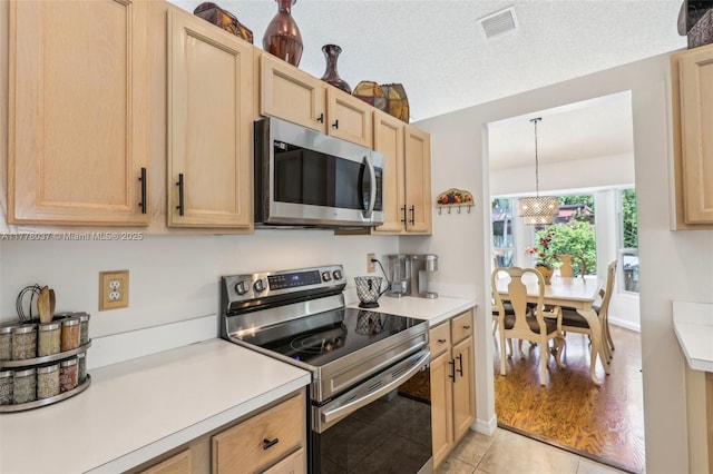 kitchen with stainless steel appliances, visible vents, light countertops, and light brown cabinetry