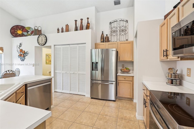 kitchen featuring light tile patterned floors, light countertops, appliances with stainless steel finishes, and light brown cabinets