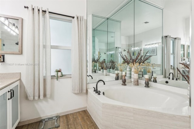 bathroom featuring visible vents, a garden tub, vanity, and wood finished floors