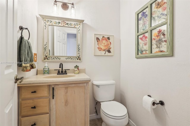 bathroom with vanity, baseboards, and toilet