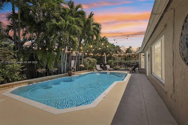 pool at dusk featuring a fenced in pool, a patio, and fence