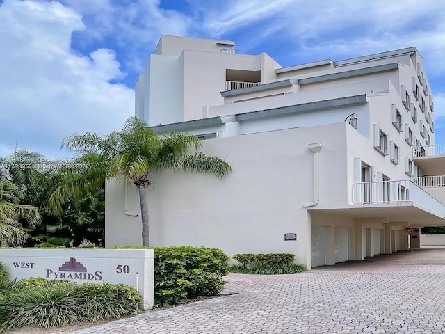 50 Ocean Lane Dr Unit 101, Key Biscayne, FL 33149 - view of property exterior with an attached garage, stucco siding, and driveway