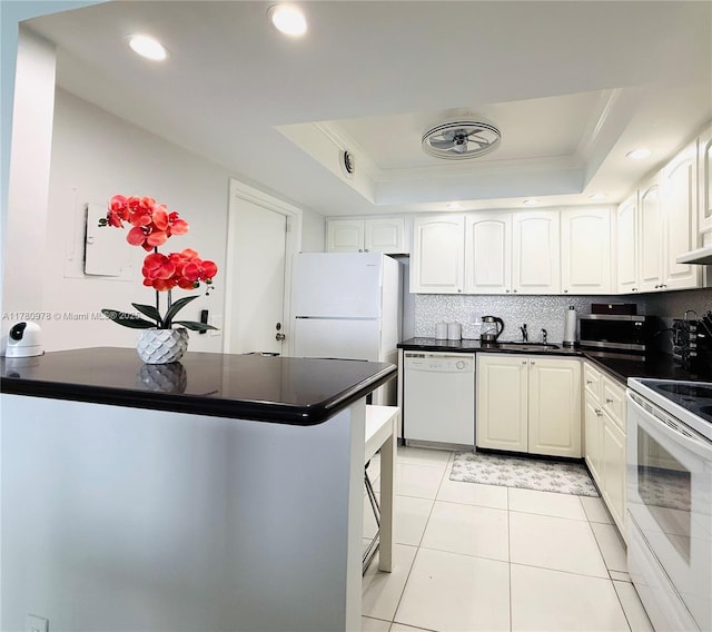 2101 S Ocean Dr Unit 1902, Hollywood, FL 33019 - kitchen with dark countertops, crown molding, a tray ceiling, and white appliances