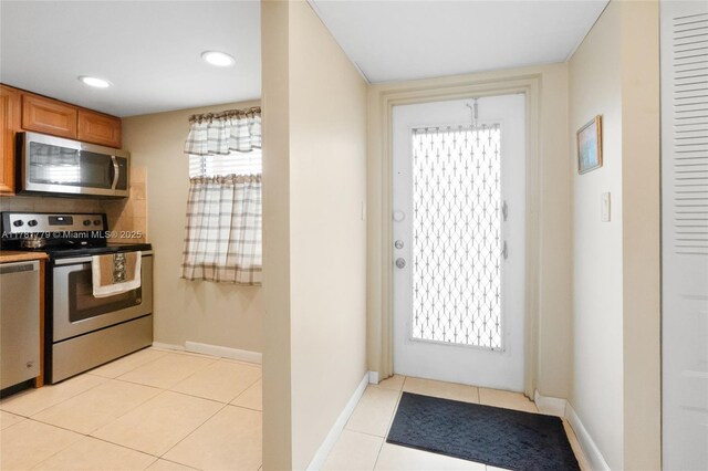 1020 Country Club Dr Unit 206, Margate, FL 33063 - kitchen featuring brown cabinets, light tile patterned floors, baseboards, and stainless steel appliances