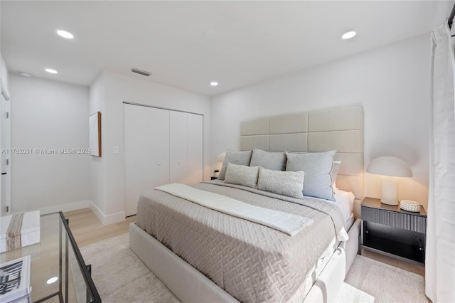 bedroom with light wood-style floors, a closet, and recessed lighting