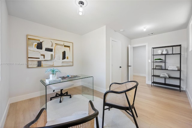 office area featuring baseboards, visible vents, and light wood-type flooring